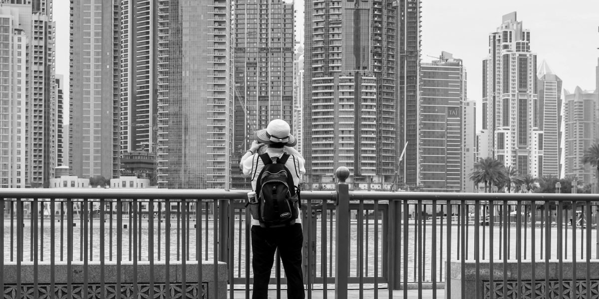A person looking at the vibrant Dubai cityscape, reflecting on housing options.