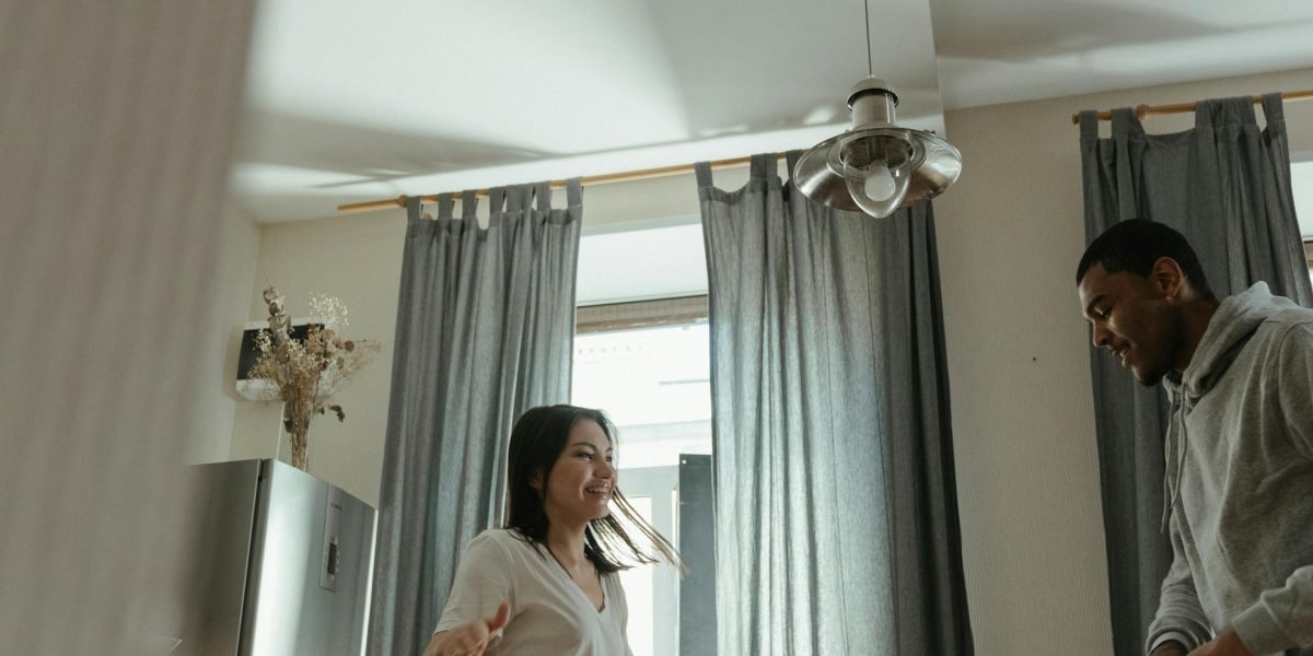 A smiling couple looking confidently at an apartment key, symbolizing the ease of finding a new home.