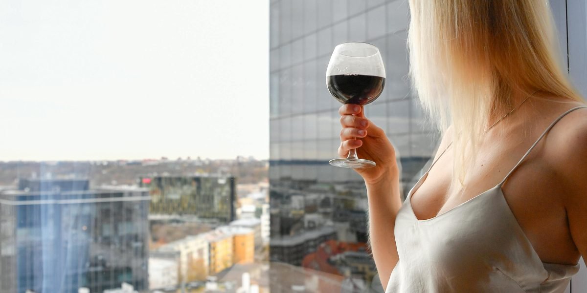 A woman enjoying the panoramic views from a luxurious apartment, symbolizing the high-end lifestyle offered.