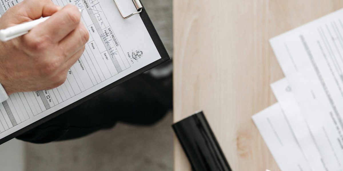 A person confidently signs a document, representing the finalization of a rental agreement with clarity and understanding.